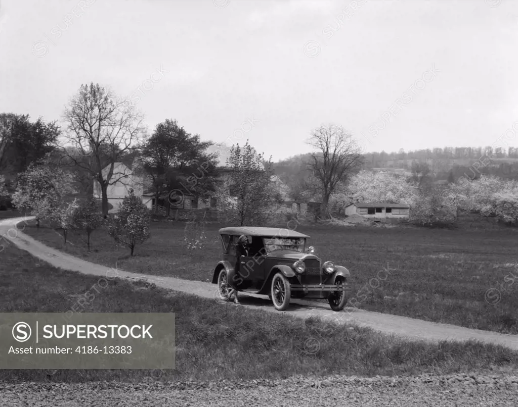 1930S 1940S Packard On Dirt Road With Woman Standing Outside Passenger Side