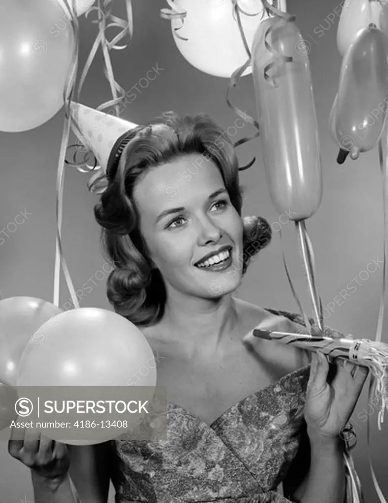 1950S Woman In Party Dress Smiling Holding Balloon And Noise Maker Indoor Studio