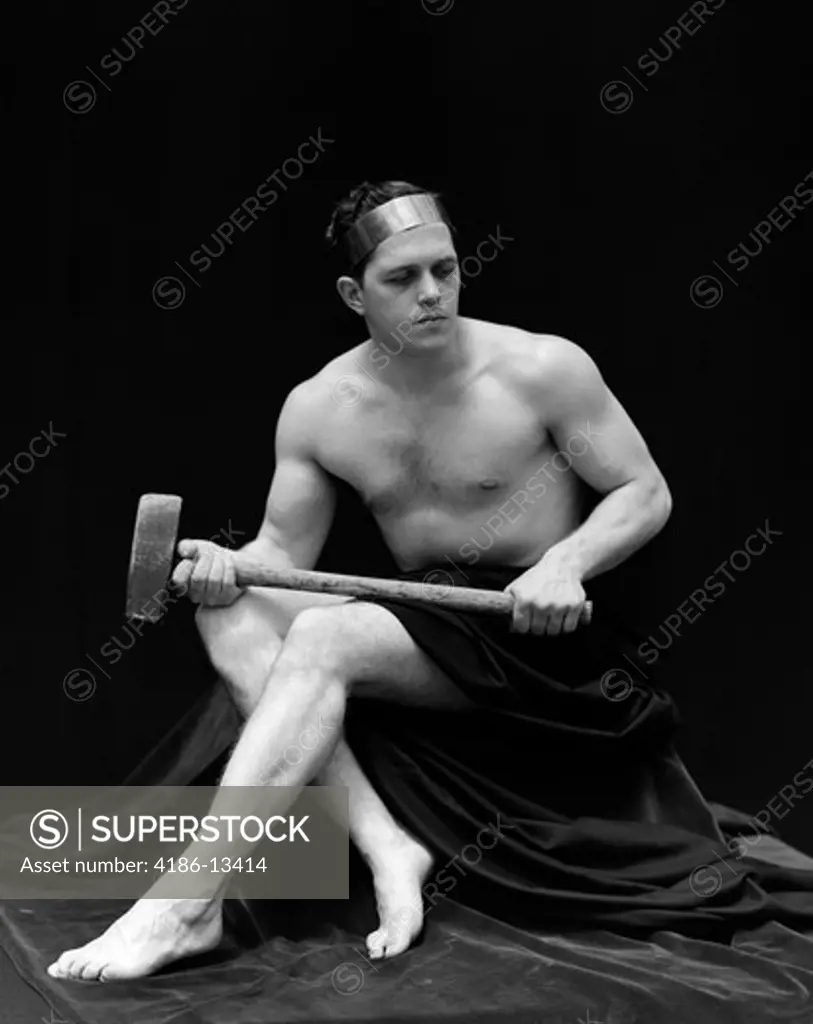 1920S Man Semi Nude Holding Long Armed Hammer Across Legs Wearing Head Band Retro Vintage