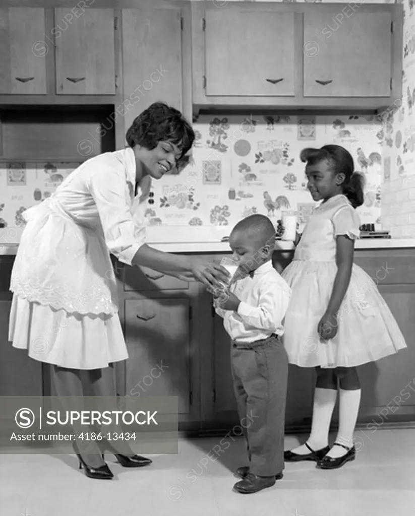 1960S Smiling African American Woman Mother In Apron And Pumps Giving A Glass Of Milk To Son And Daughter With Mary Jane Shoes