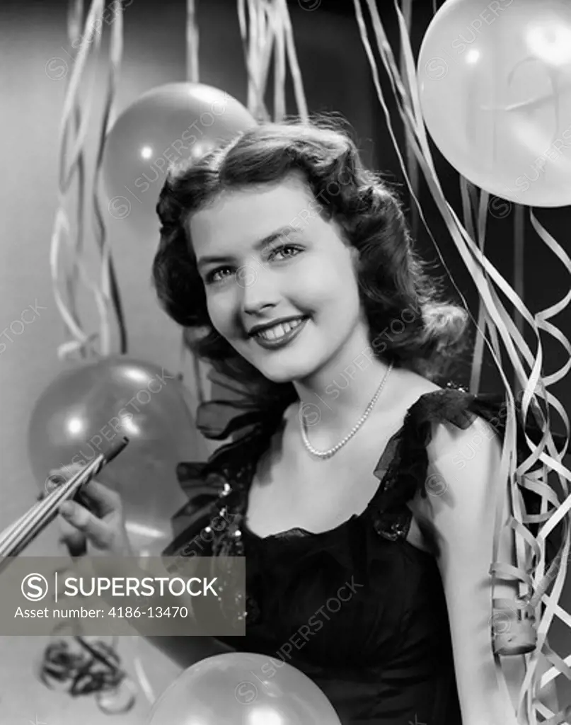 1940S 1950S Smiling Woman Black Party Dress Pearls Holding New Year Party Noise Maker Streamers Balloons Background