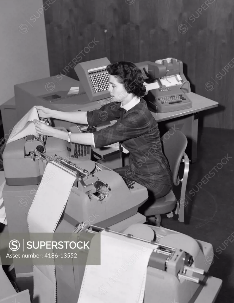 1950S Woman At Work Station Surrounded By Accounting Machines Spewing Out Paper