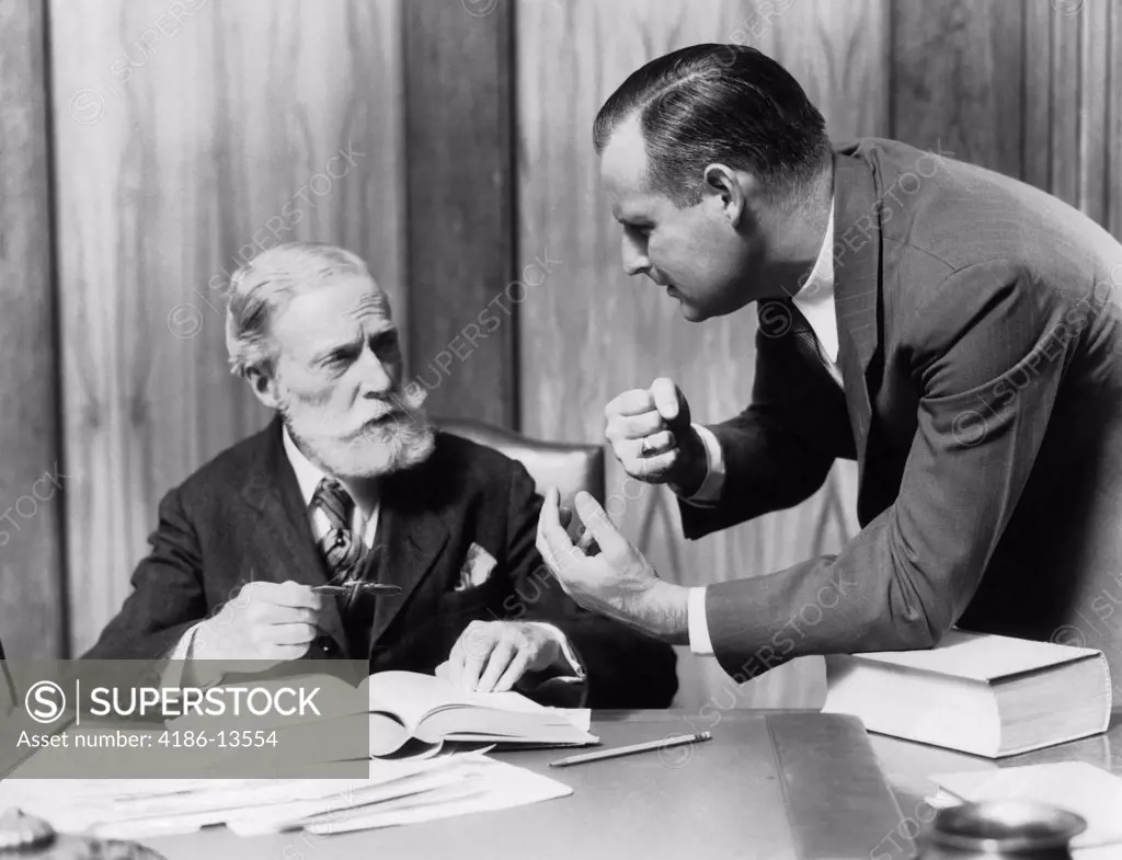 1930S Two Men In Office At Desk Talking