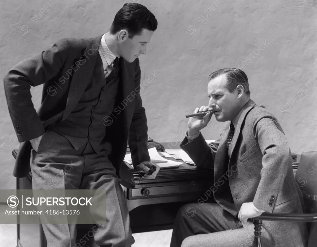 1930S Two Men At Desk Talking One Man Smoking Cigar