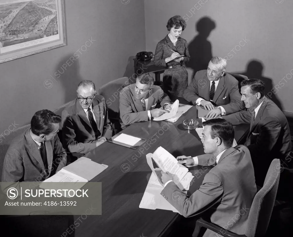 1950S Group Of Businessmen Having Meeting Around Table Female Secretary Takes Notes Indoor