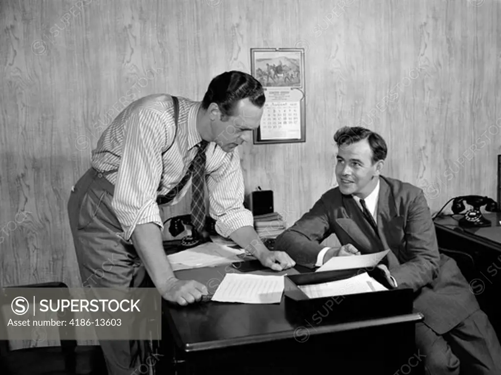 1940S Two Men At Desk In Wood Paneled Office Room