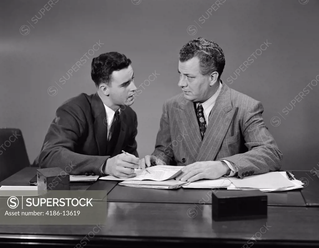 1940S 1950S Two Men Seated Desk Looking Over Business Papers