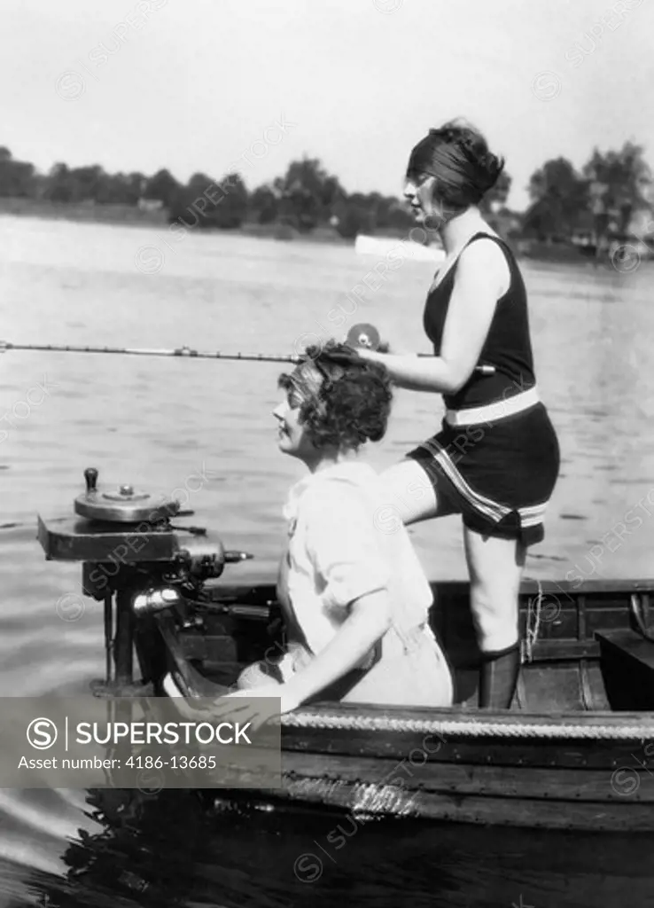 1920S 1930S Two Women Fishing From Stern Of Small Boat With Motor Outdoor One Woman Wi Wearing Bathing Suit