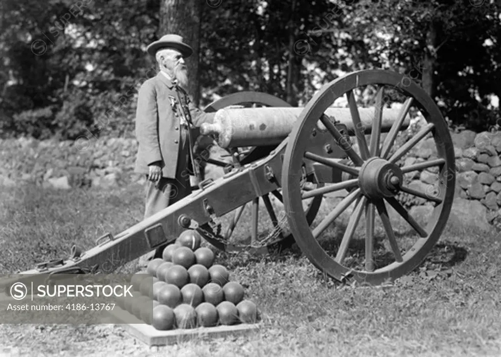 1890S 1900S Elderly Bearded Man Confederate Civil War Veteran With Military Decorations On Coat Standing Next To Cannon