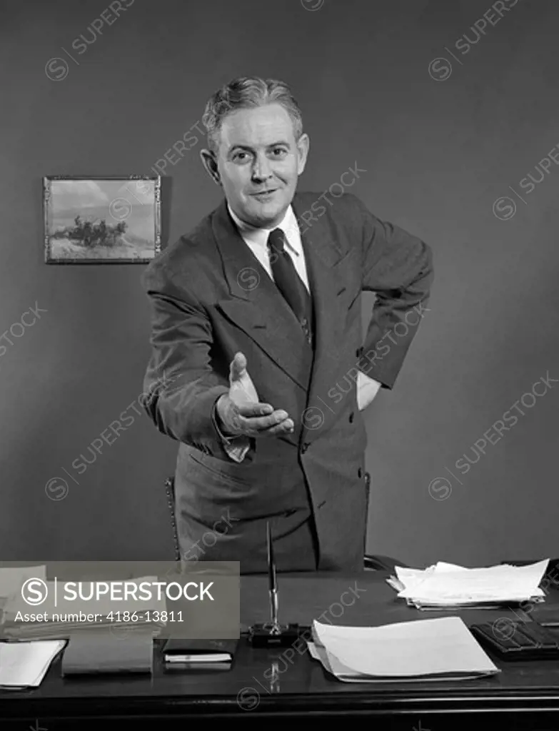 1950S Man Smiling Businessman Salesman Reaching Across Desk To Shake Hands