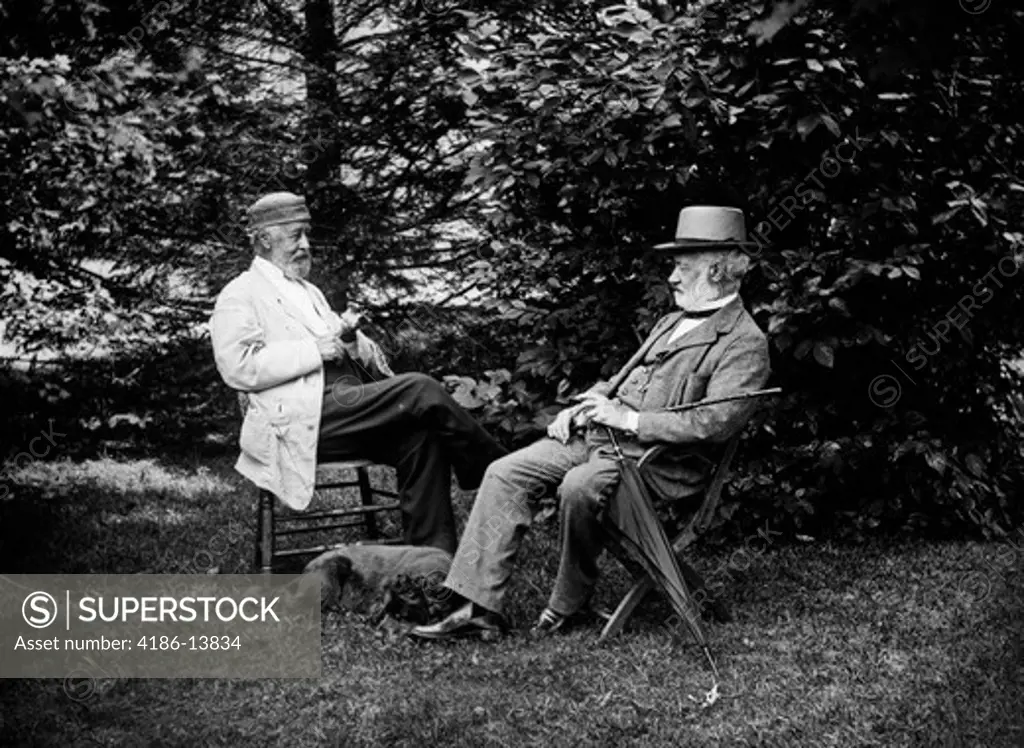 Turn Of The Century Two Men Sitting Outside In Chairs Among Trees Smoking Cigars Talking Dog Laying At Their Feet