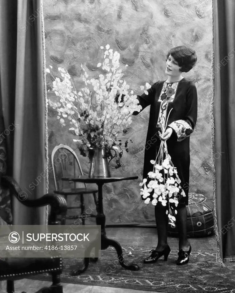 1920S Woman Arranging Flowers In Aluminum Pitcher