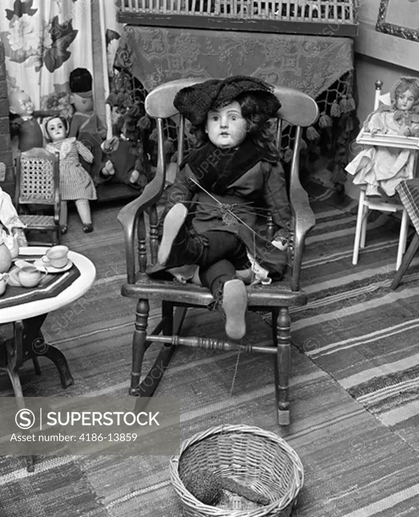 Victorian Doll Sitting Cross-Legged On Small Rocking Chair