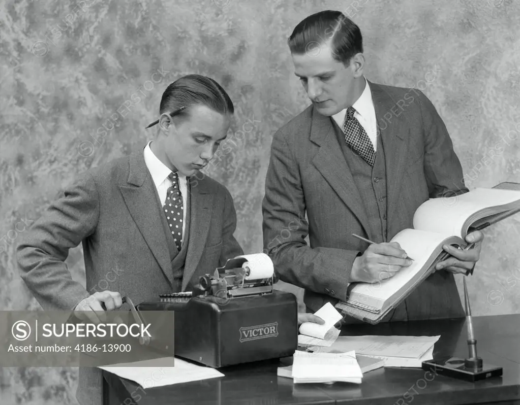 1930S Clerk And Young Assistant In Office Using Ledger Book & Adding Machine