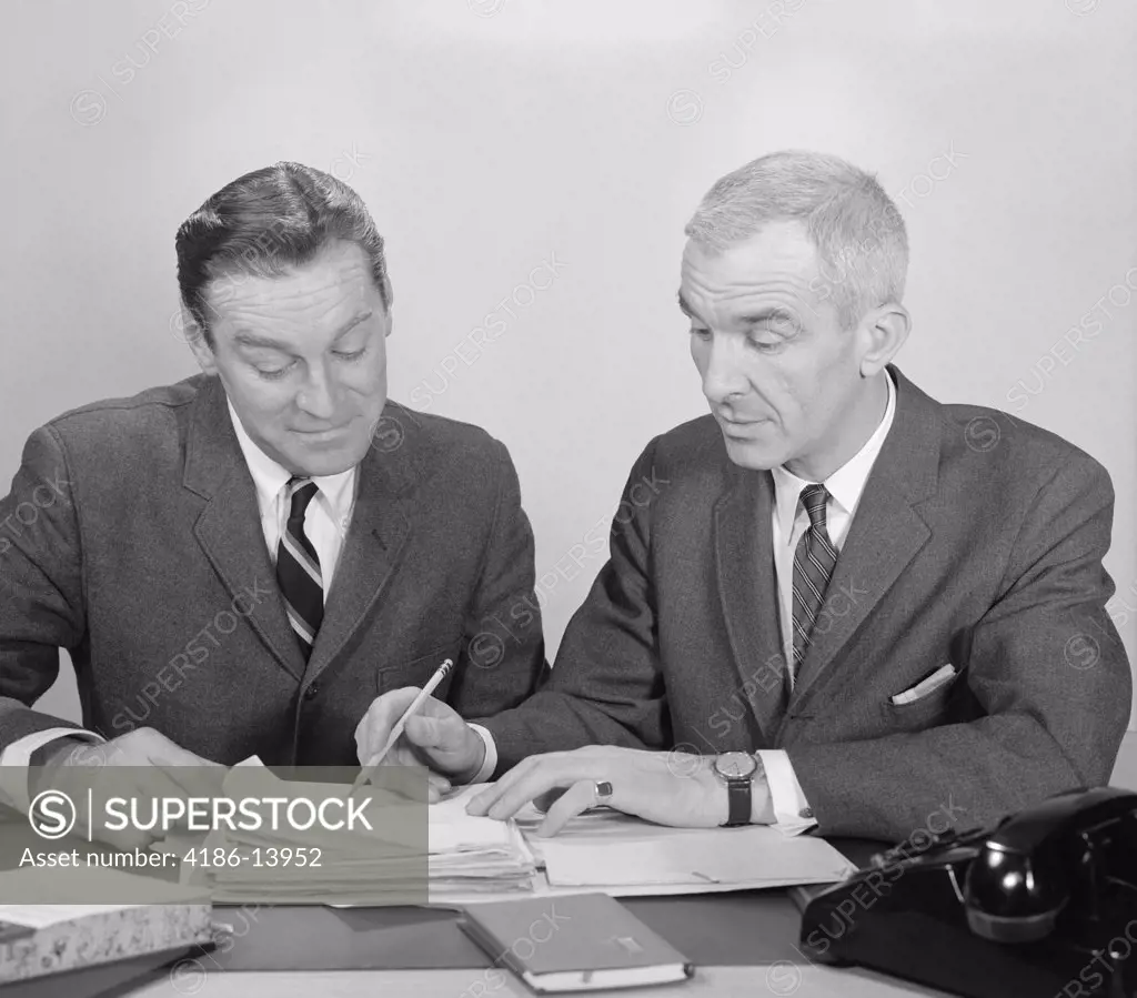 1960S Two Businessmen Seated At Desk Looking At File Folders