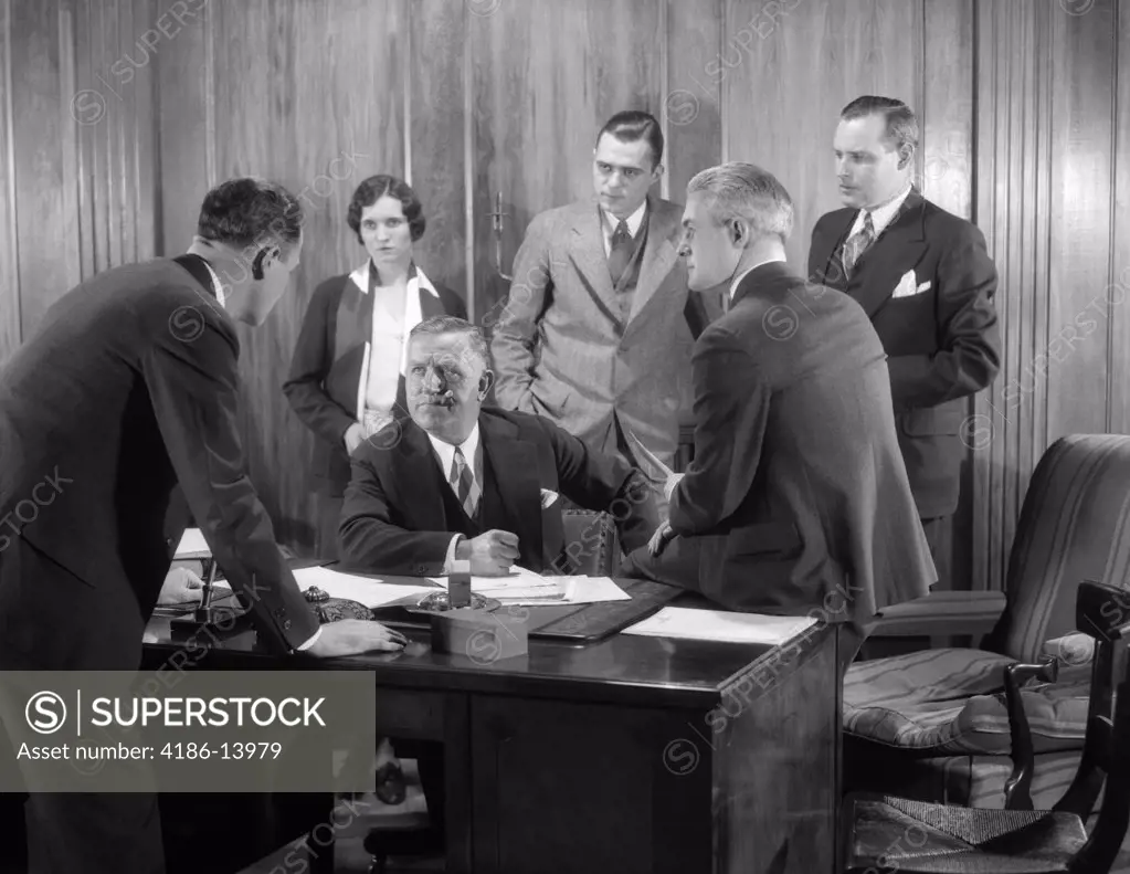 1930S Worried Business Group Five Men And One Woman In Office Meeting Around The Boss' Desk