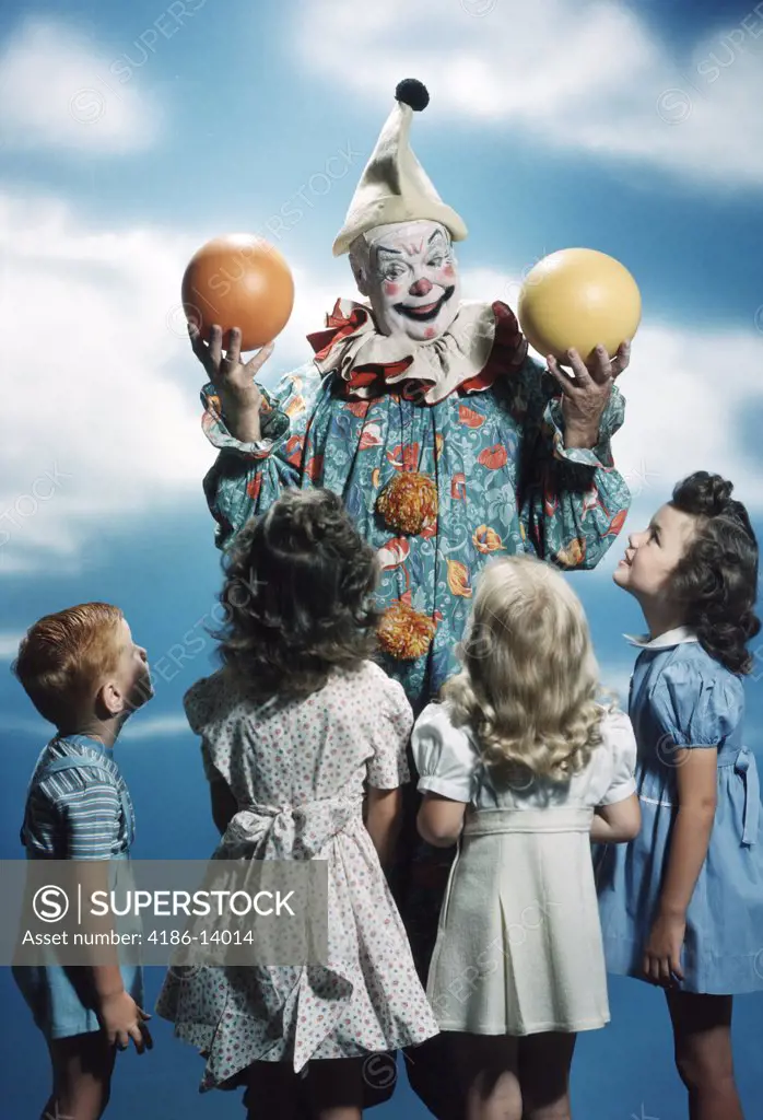 1940S 1950S Group Of Children Watching A Clown Handle Orange And Yellow Balls