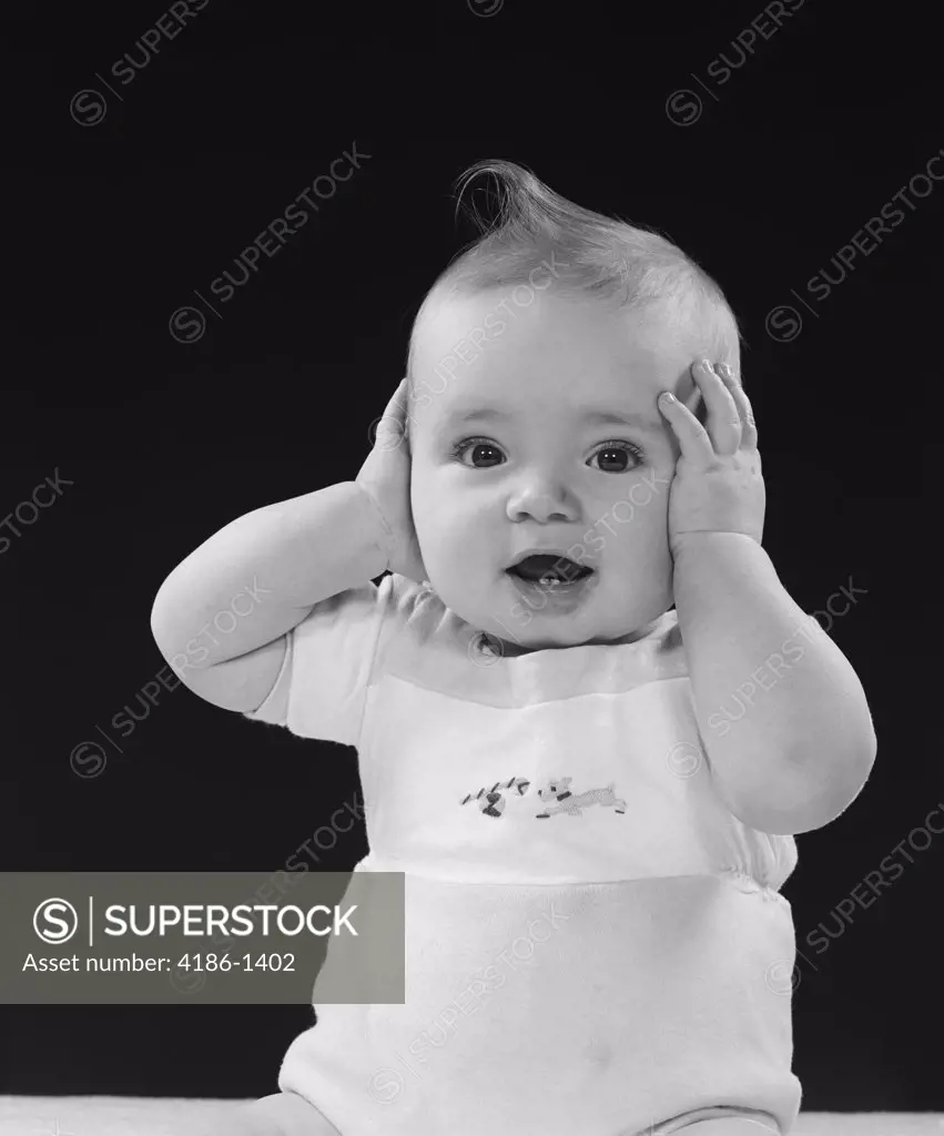 1950S Baby With Hands Up To Side Of Head Covering Ears