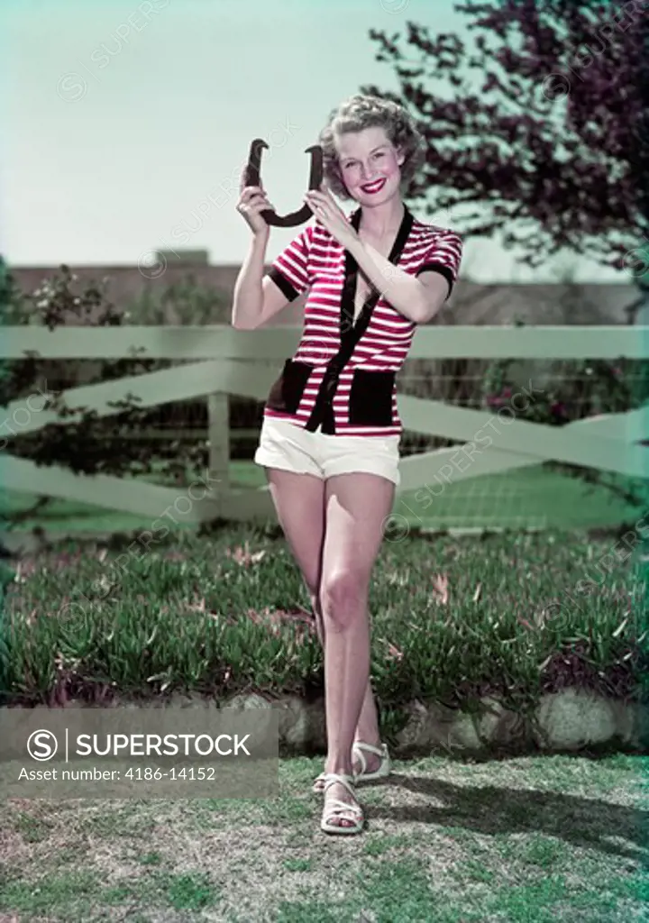 1940S 1950S Smiling Woman Holding Pitching Horseshoe Fence In Background