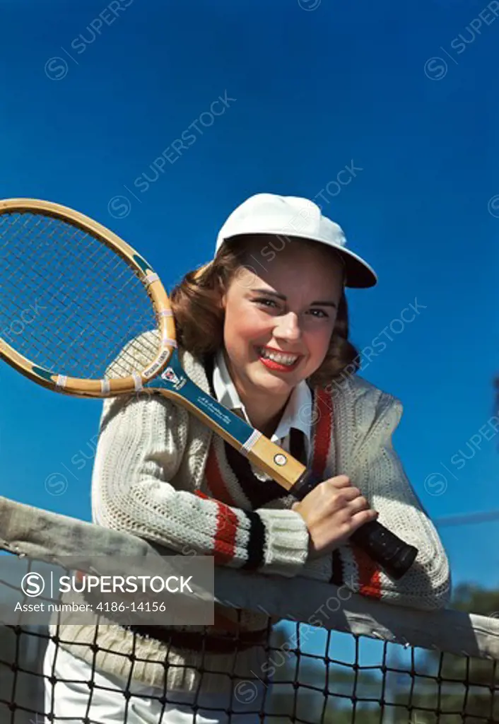 1940S 1950S Smiling Teen Girl Holding Tennis Racquet Leaning Over Tennis Net