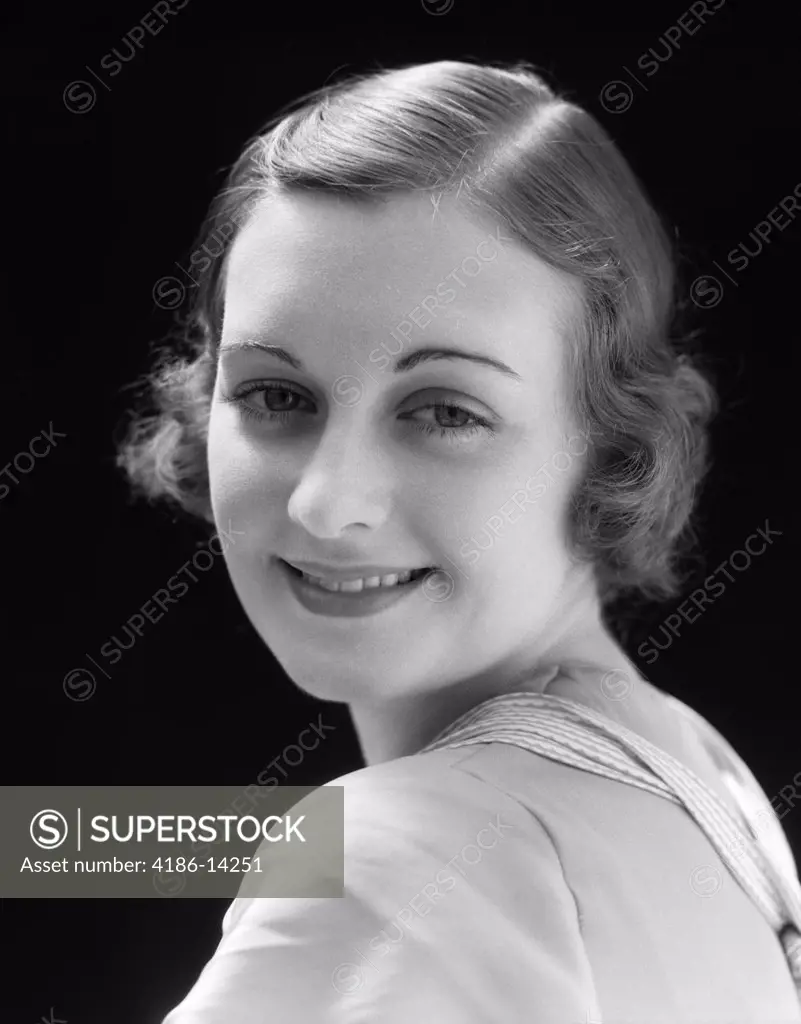 1930S Smiling Young Woman Looking Over Her Shoulder At Camera