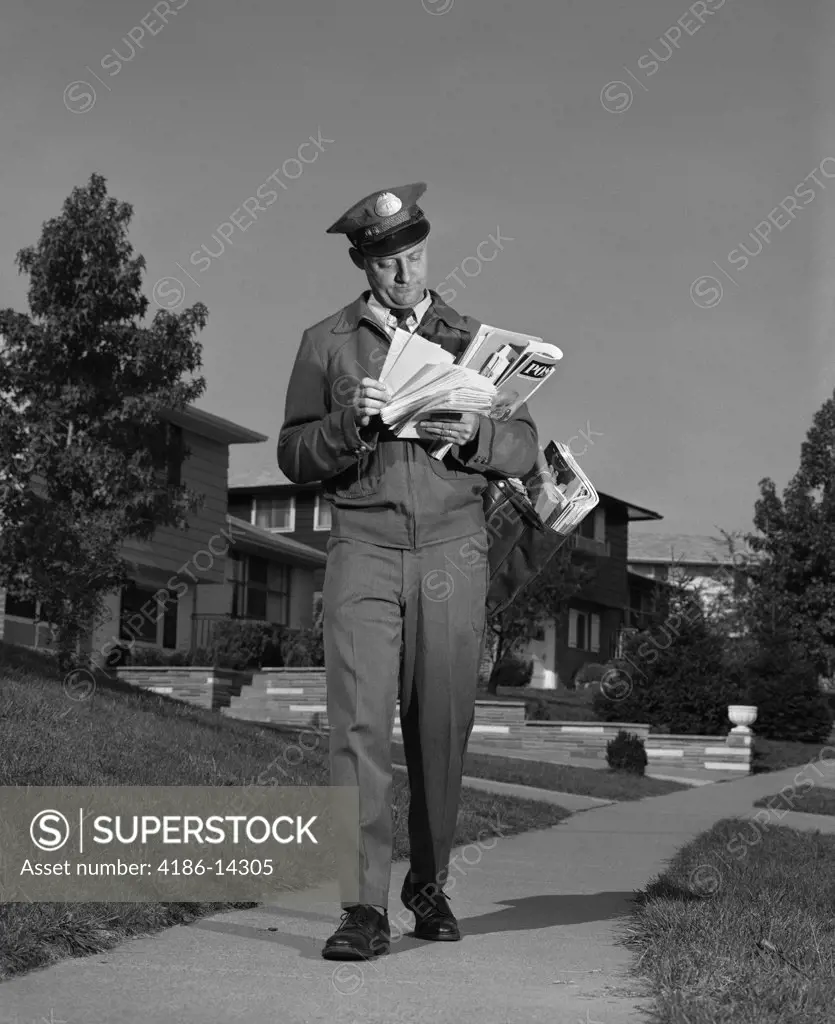 1960S Postman Delivering Mail Suburban Neighborhood Sorting Letters Walking On Sidewalk