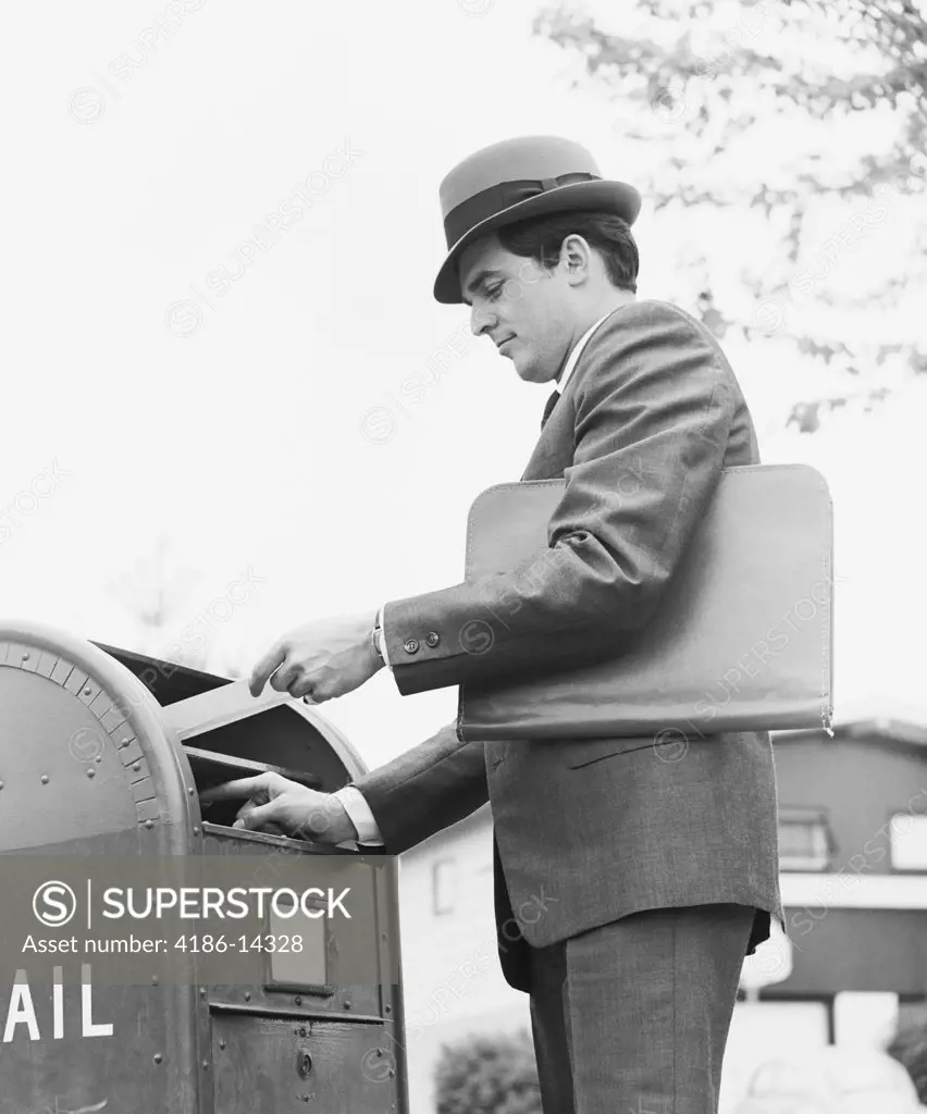 1970S Young Businessman With Briefcase Dropping Letter Into Mailbox