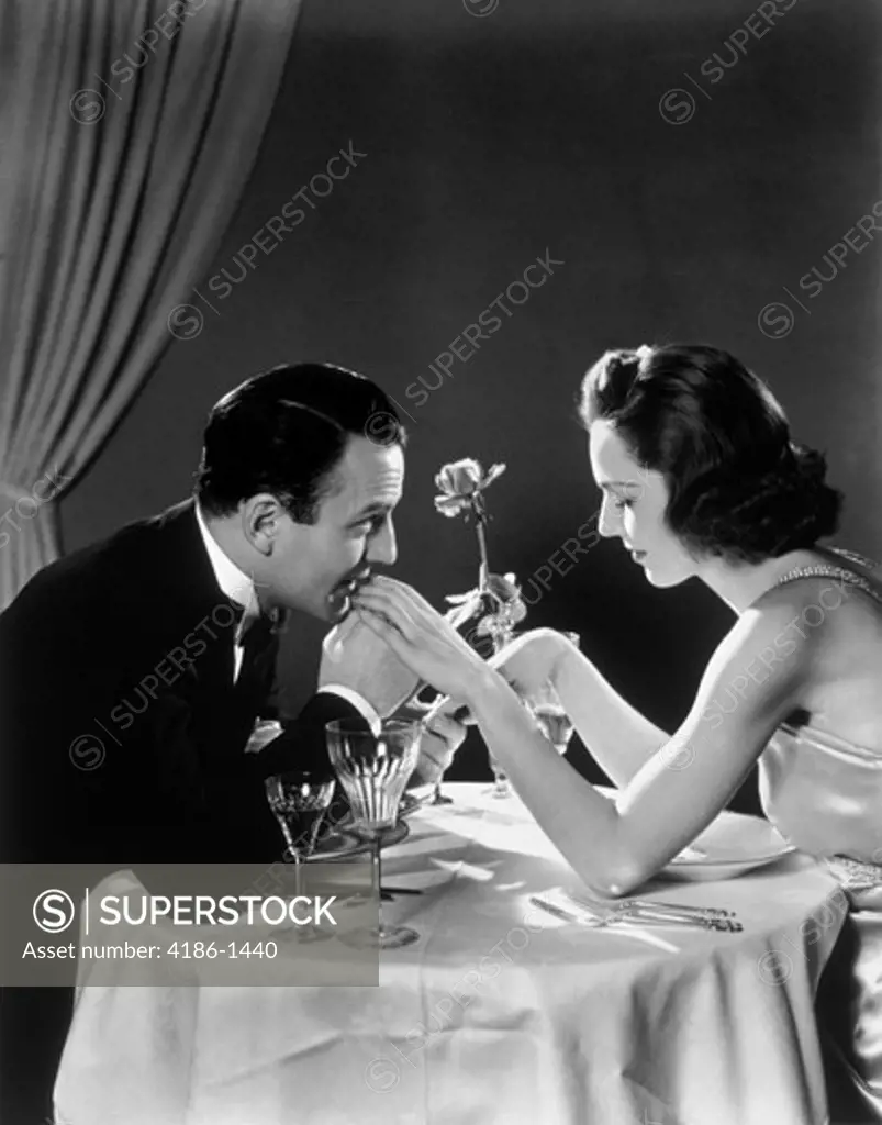 1930S Romantic Couple At Dining Table Man Kissing Woman'S Hand