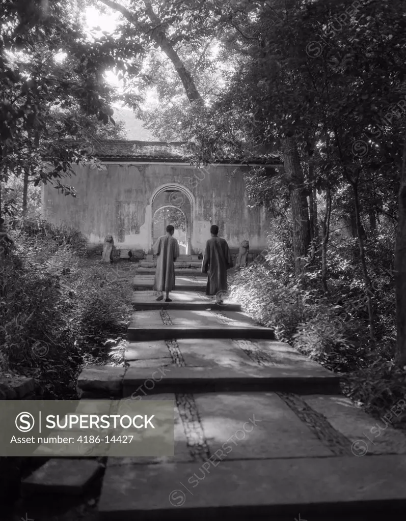 1920S 1930S Two Chinese Men In Robes Walking Up Quiet Garden Path