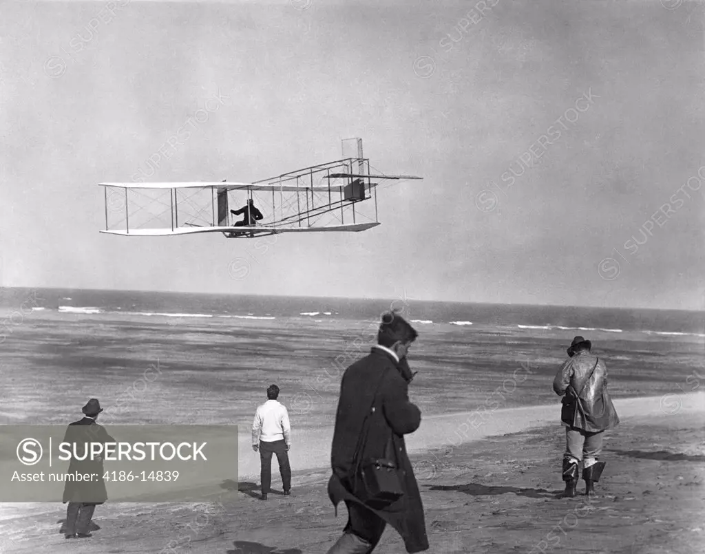 One Of The Wright Brothers Flying Glider By The Ocean And Spectators On Beach Below Kitty Hawk North Carolina Usa