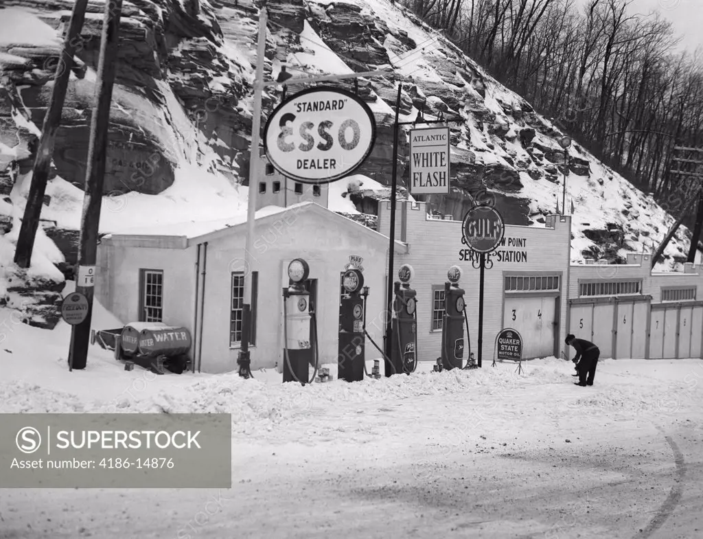 1940S Service Station In Mountains In Winter Several Gas Pumps Garages & Oil & Gas Signs