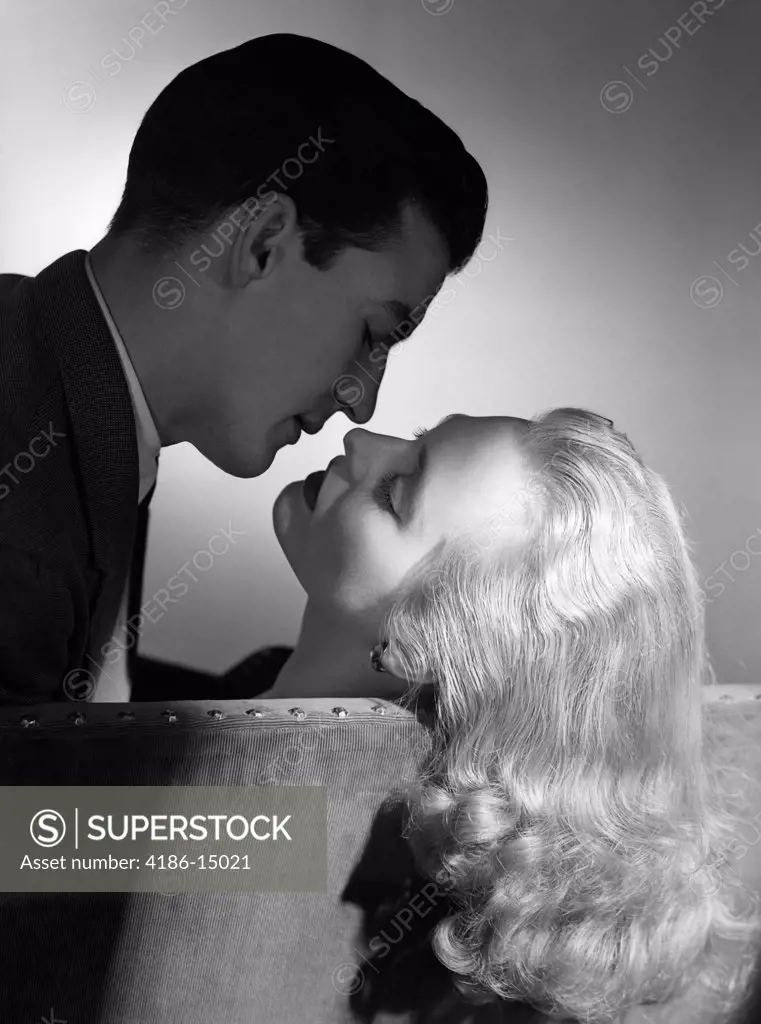 1940S 1950S Movie Star Studio Style Romantic Couple Embracing On Sofa About To Kiss Husband Silhouette Wife Long Blond Hair