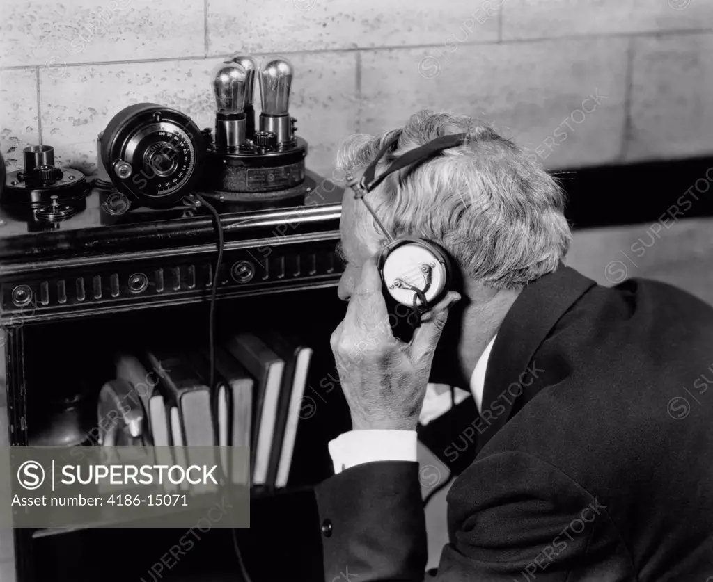 1940S Elderly Man Listening To Crystal Radio Through Headphones