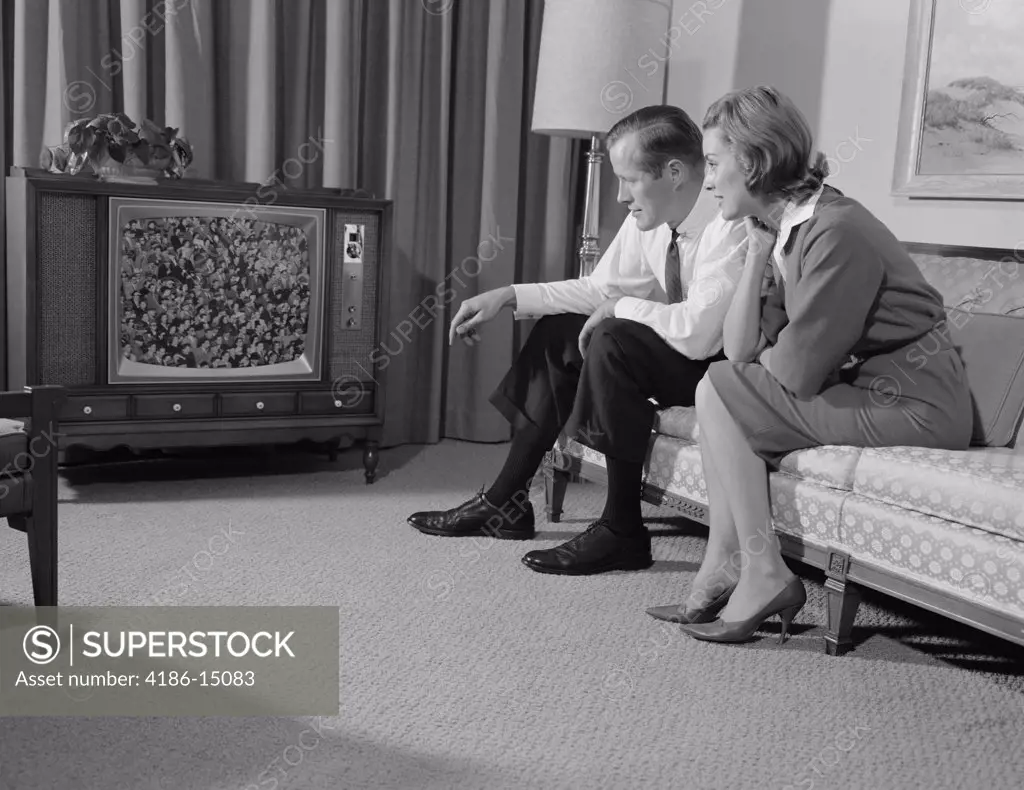 1960S Couple Man Woman Sitting On Couch Watching Television