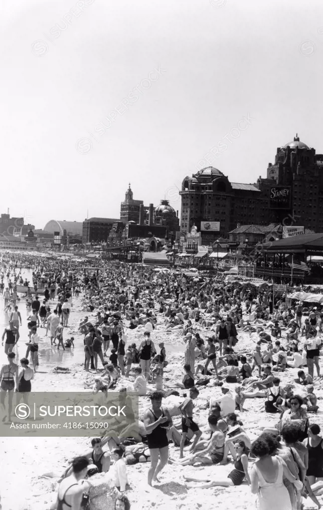 1940S Beach Crowd Of Sunbathers On The Sand In Swimsuits With The Boardwalk In The Background Atlantic City New Jersey
