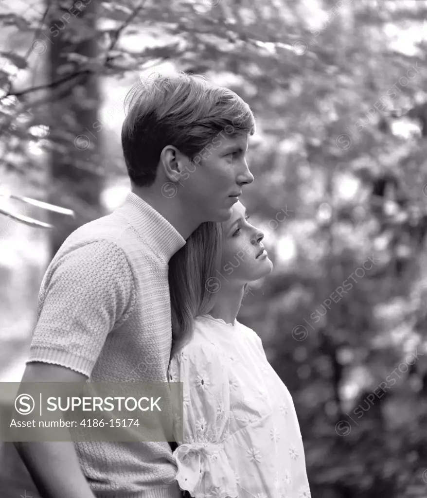 1970S Side View Of Couple Standing In Woods Woman Leaning Back Against Man