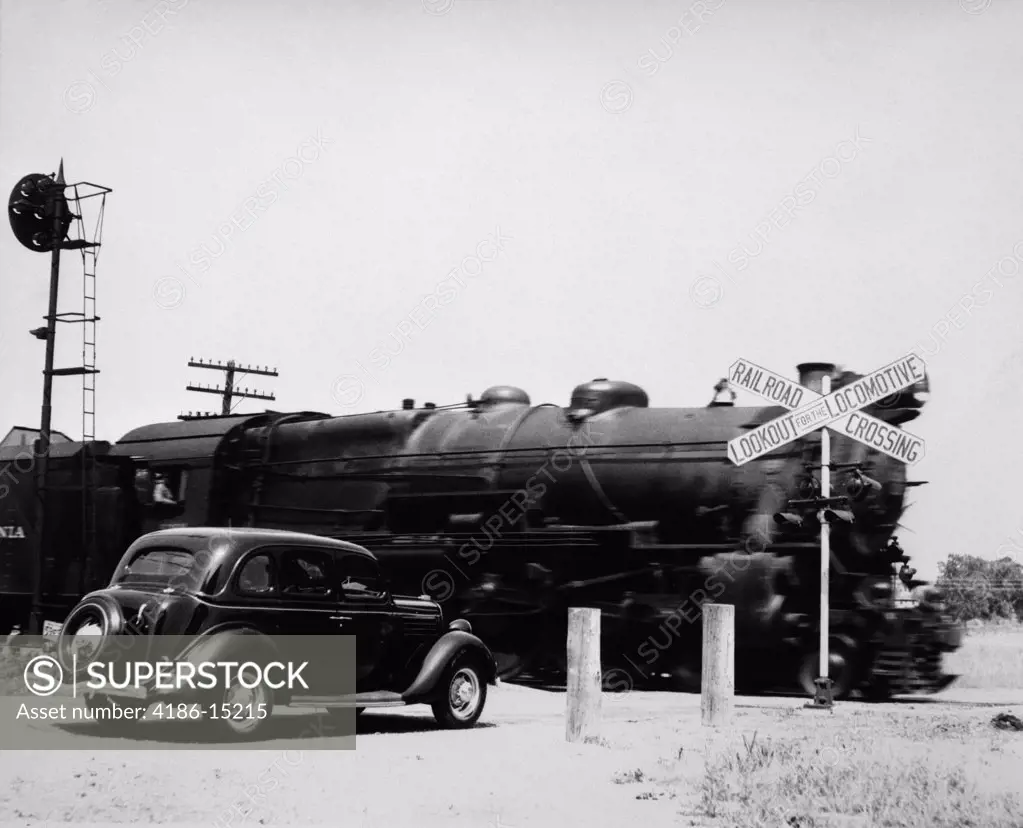 1930S Car Stopped At Railroad Crossing With Freight Train Speeding By
