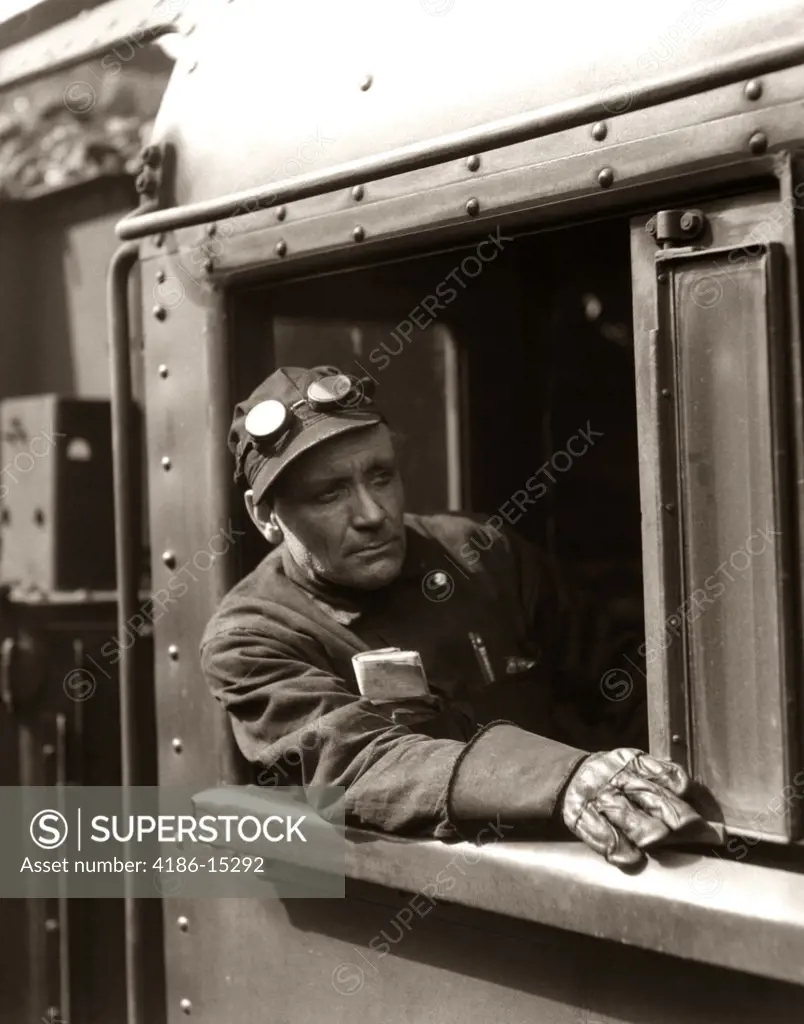 1920S 1930S 1940S Railroad Train Engineer Looking Out Window Of Locomotive Cab Driving The Steam Engine