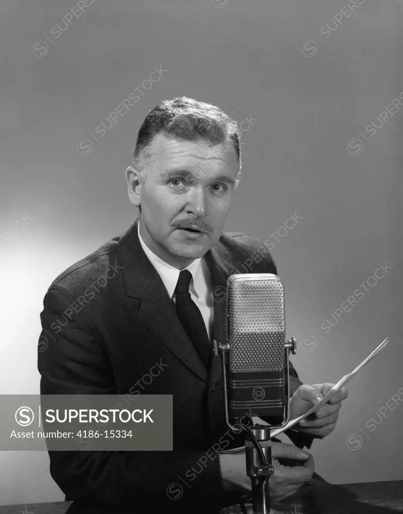 1950S 1960S Older Man Speaking Into Microphone Holding Papers Radio Television Newsman Reporter Announcer
