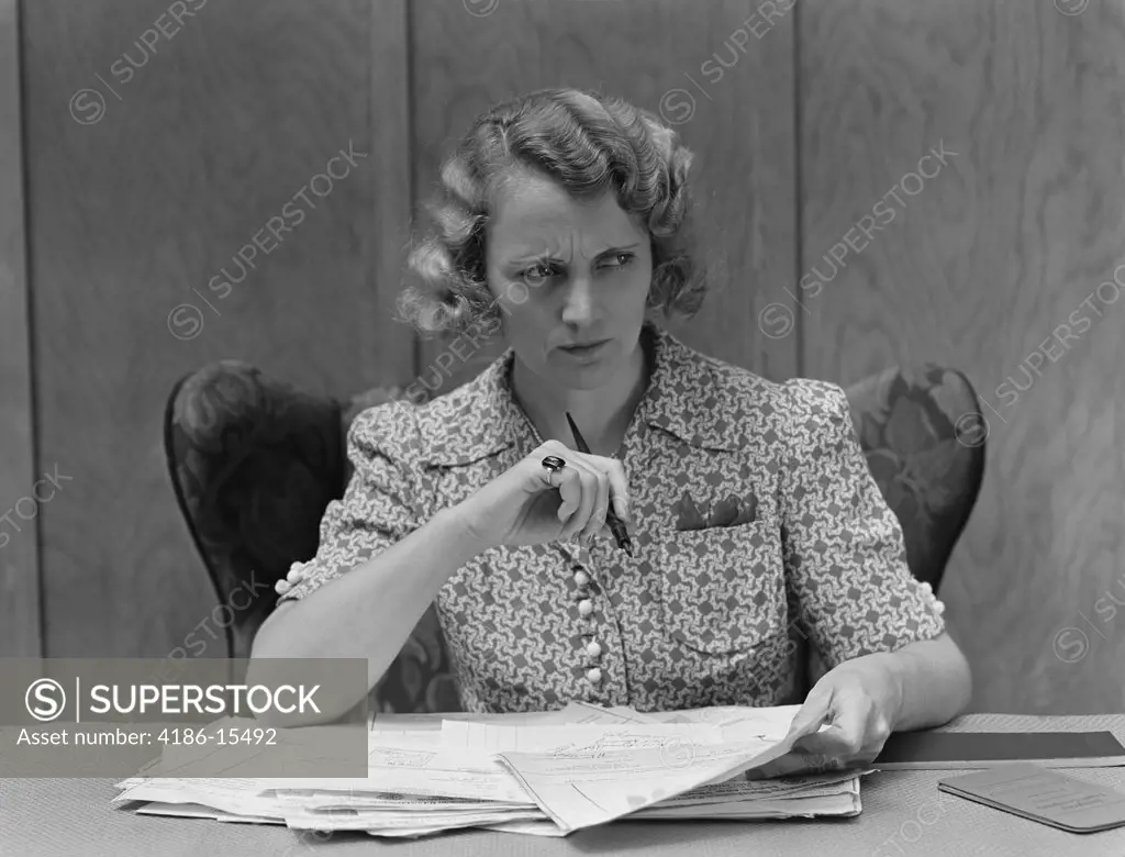 1930S Serious Worried Woman At Desk Going Over Papers Bills Looking Off To Side
