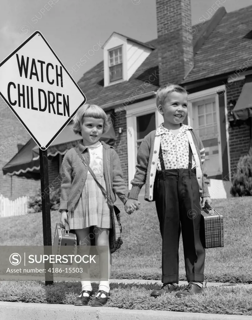 1960S Boy & Girl Dressed Up For School Carrying Plaid Lunchboxes Holding Hands Standing By Watch Children Sign