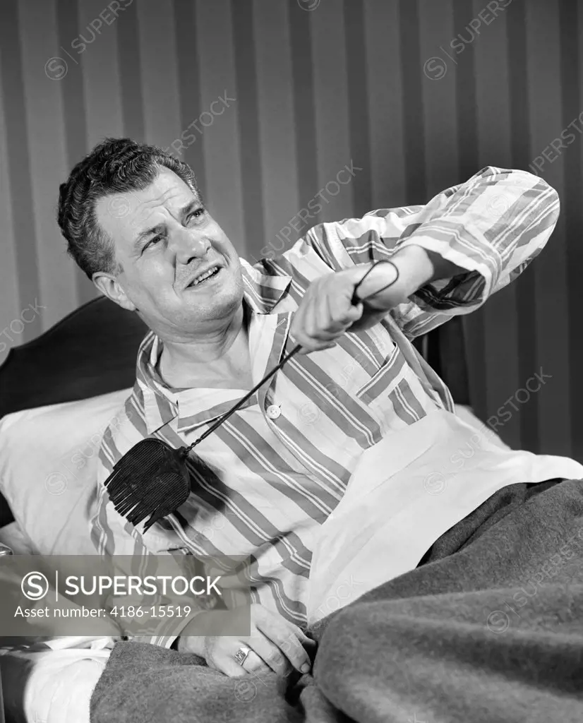 1940S Man Sitting In Bed With Flyswatter