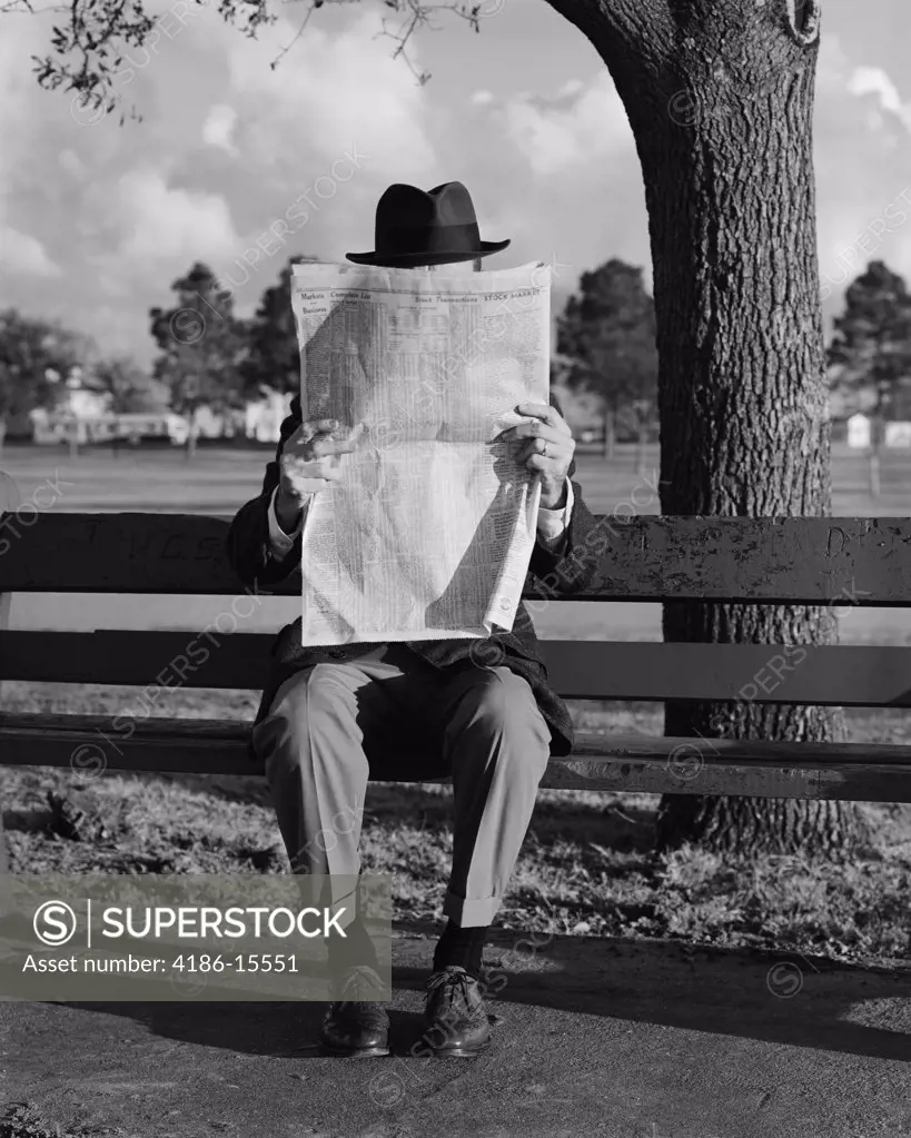 1960S Humor Portrait Man Wearing Hat Sitting On Park Bench Reading Newspaper  