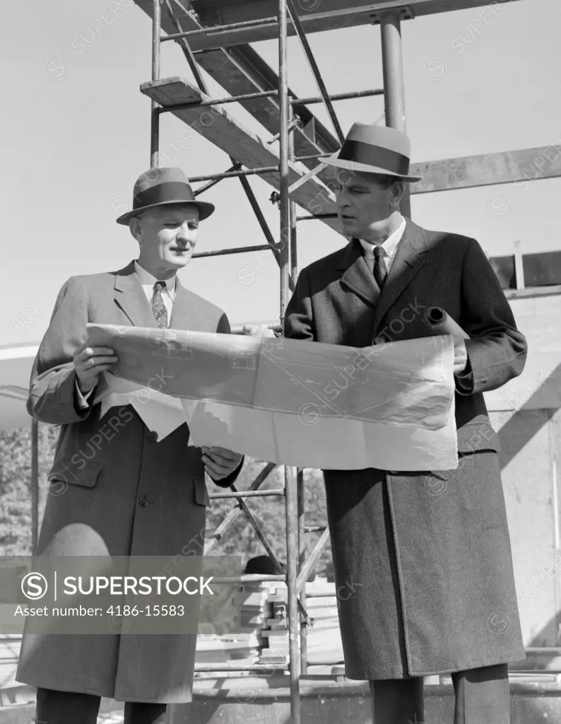 1960S Two Businessmen Reviewing Blueprints At Construction Site Outdoor