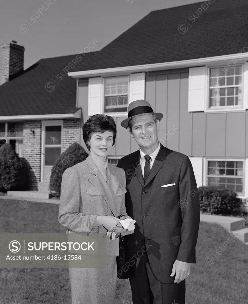 1960S Couple Smiling Man And Woman Standing Before Suburban House
