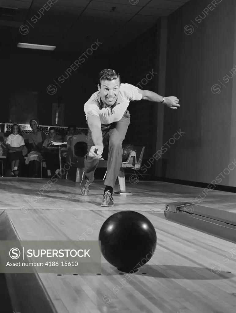 1960S Man Releasing Ball Down Bowling Alley Lane