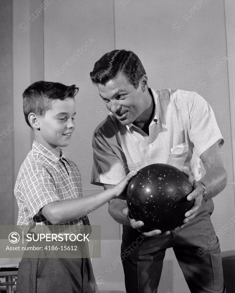 1960S Father Showing Son How To Hold Bowling Ball Indoor