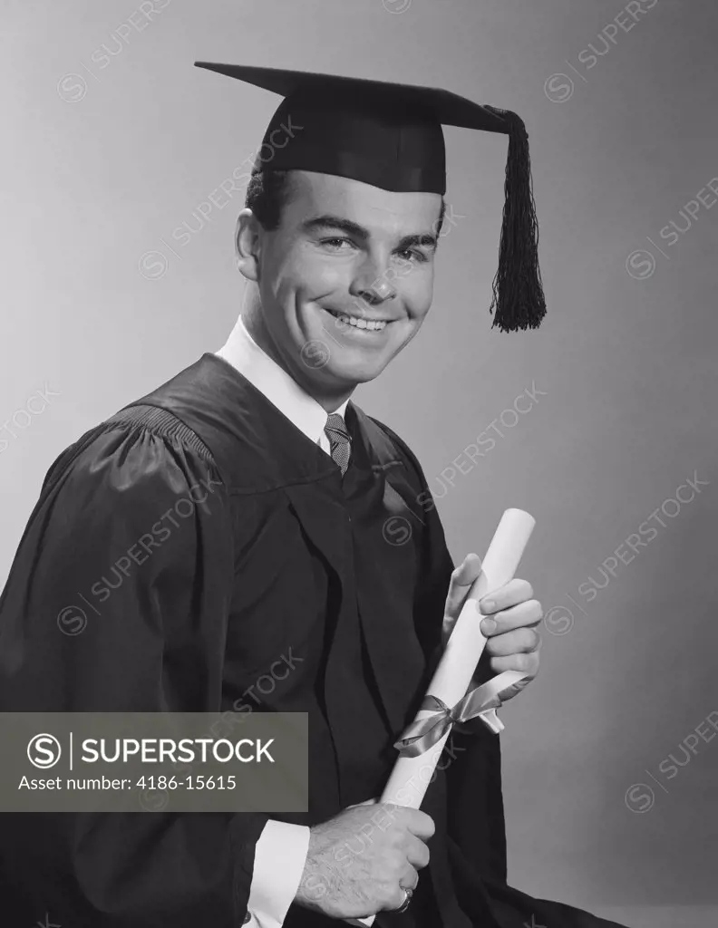 1960S Smiling Man Holding Diploma Wearing Graduation Robes