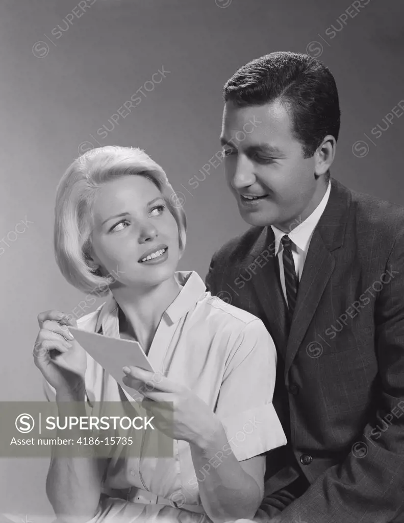 1960S Couple Reading List Man Looking Over WomanS Shoulder