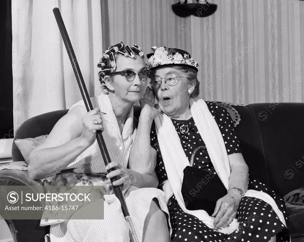 1950S 1960S Two Elderly Women Characters Gossiping One Woman With Hair Curlers Other With Hat